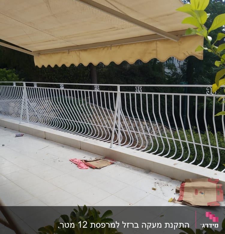 מעקה מתכת לבן עם עיטורים על מרפסת